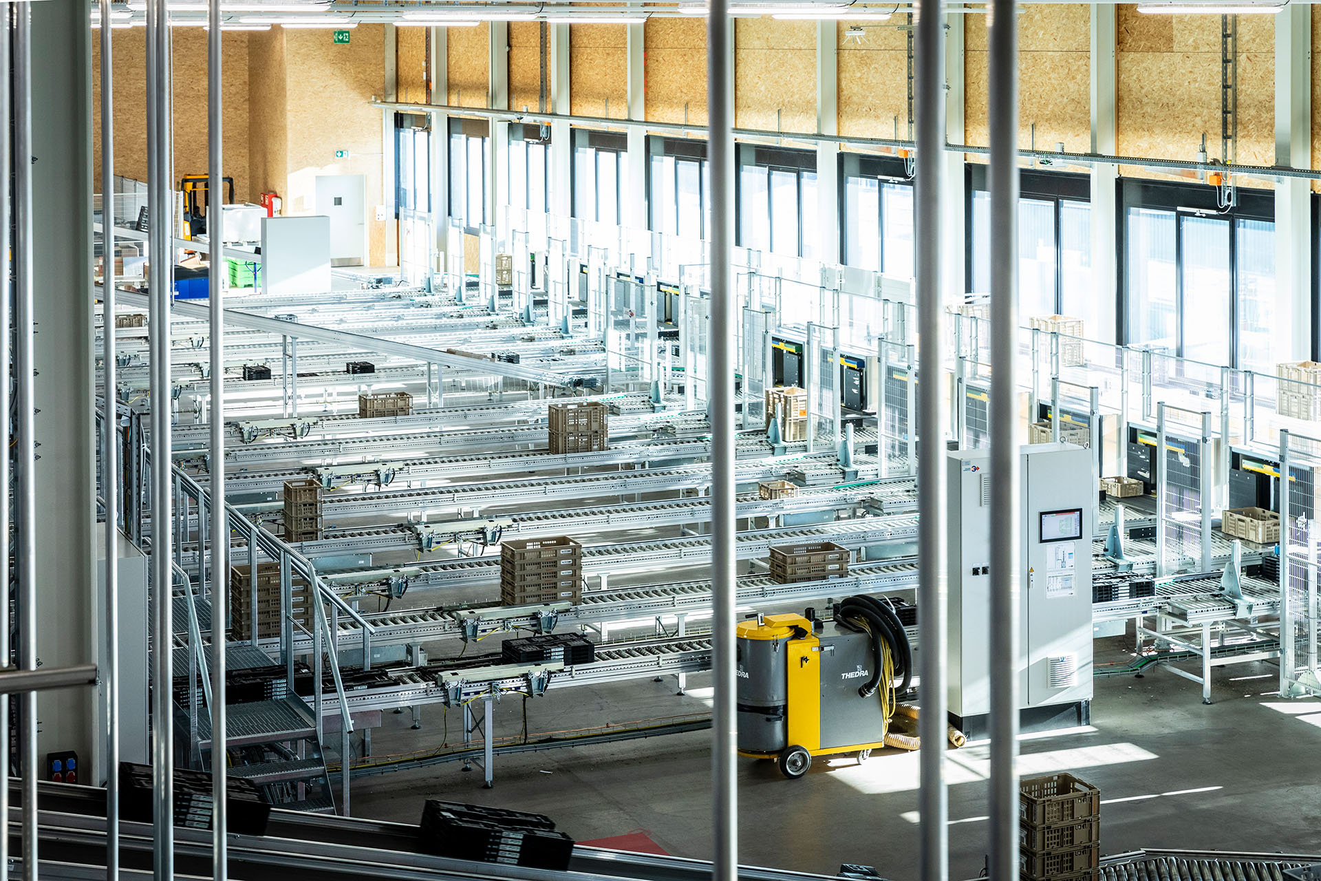 Die leeren Mehrwegkisten werden  zur neuen vollautomatischen Gebindesortieranlage befördert .