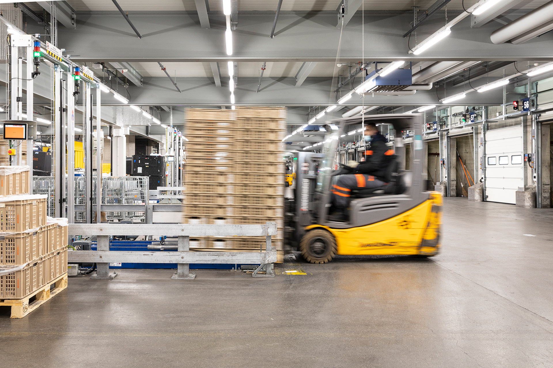 Gebinde mit vorsortierten Altstoffen und Mehrwegkisten werden auf die neue vollautomatische Förderanlage gestellt.