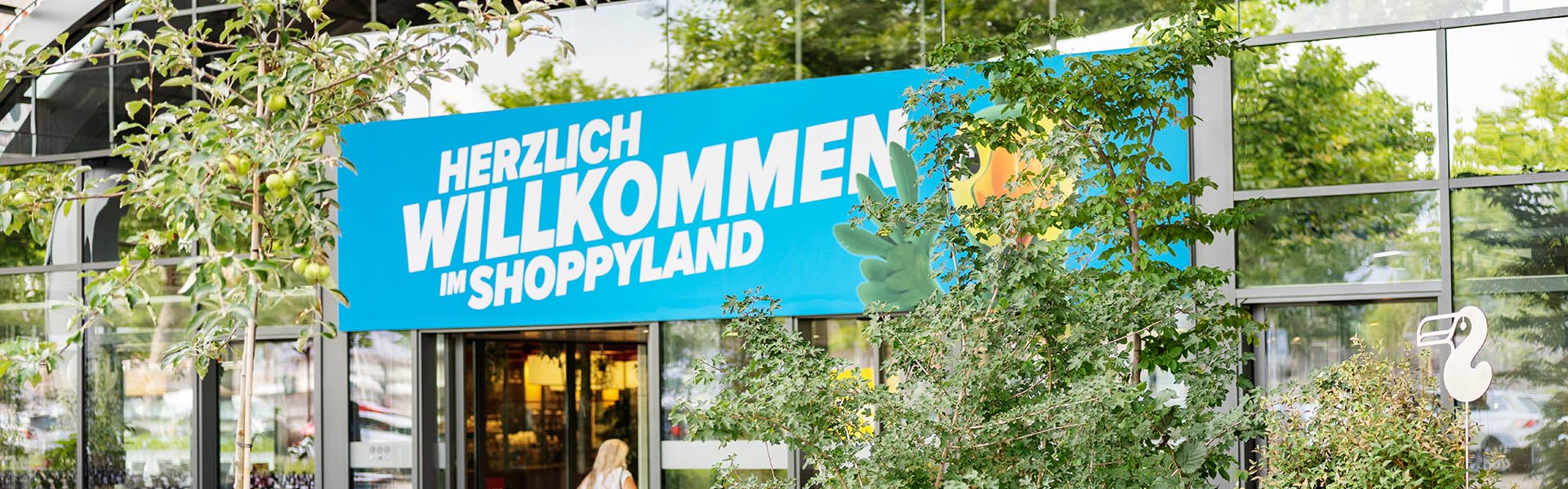 Eingang Shoppyland mit vielen Pflanzen