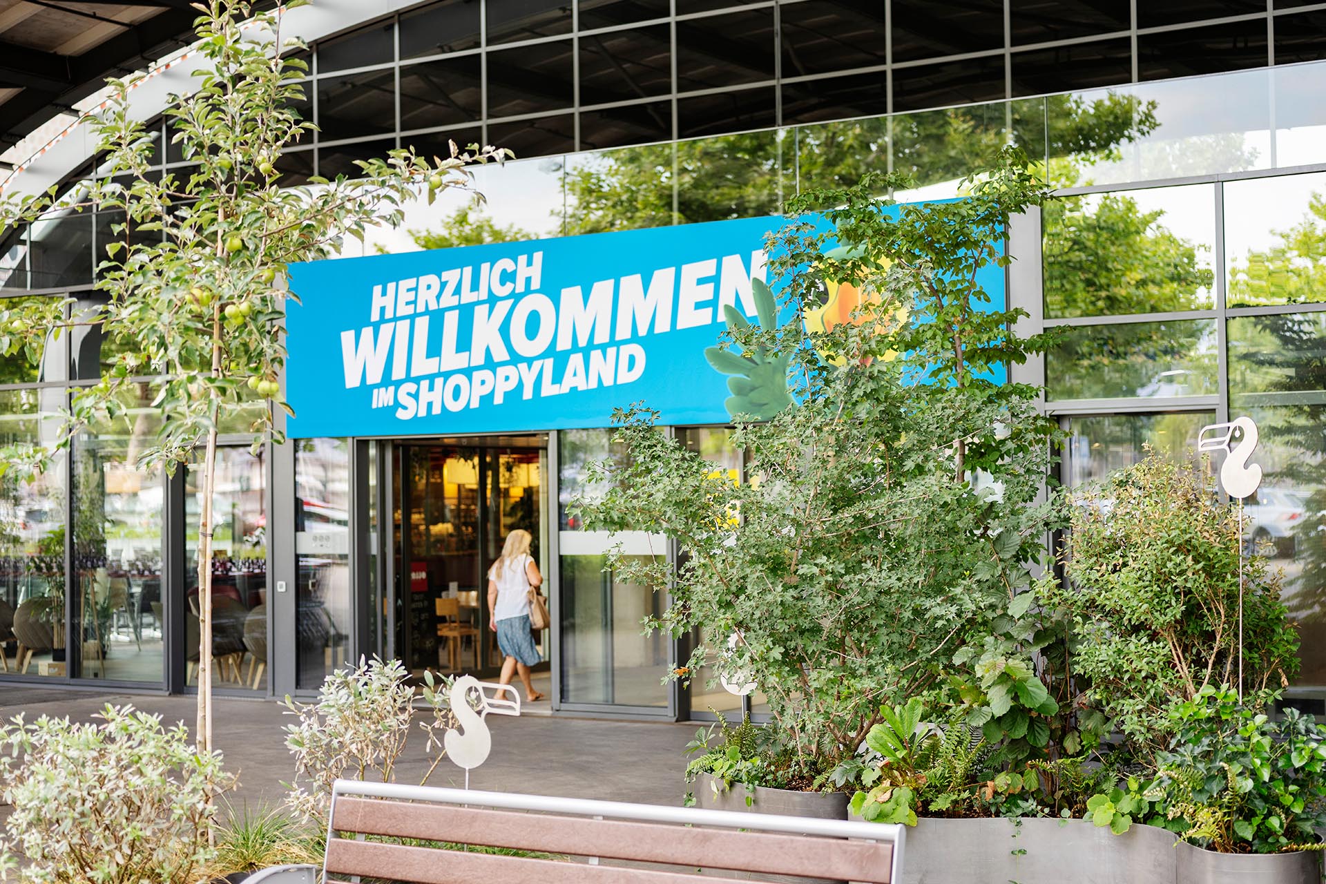 Eingang Shoppyland mit vielen Pflanzen